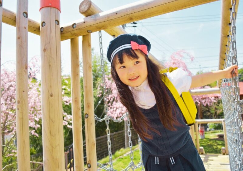 笑顔で遊んでいる制服を着た幼稚園の女の子